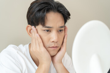 Asian men worry about acne on their faces when looking in the mirror