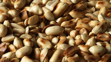 Roasted peanuts scattered on wooden table.