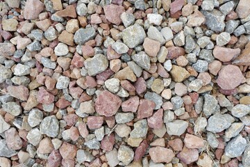 A mixture of small rocks in various shades is spread across a surface.