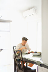 Man in His 30s Eating Muesli at the Kitchen Table During Morning Routine.