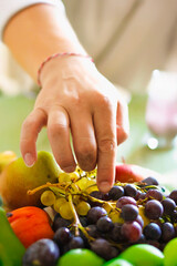 A man reaching for some grapes.