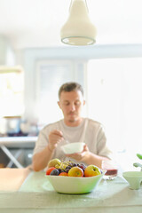 Man Chewing a Bite of Oats While Sitting an his Dinning Table.