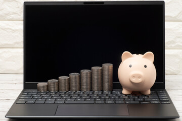 パソコンとブタの貯金箱とお金