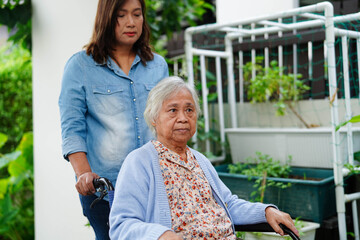 Caregiver help Asian elderly woman disability patient sitting on wheelchair in hospital.