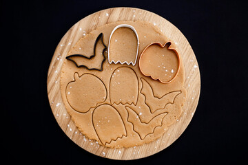Halloween gingerbread cookies on a dark background. Homemade cookies for Halloween party - pumpkin, ghost, bat, mummy, skeleton. Halloween background with space for text. Top view. Mock up
