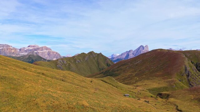 Veduta aerea mozzafiato delle Dolomiti con valli verdi, sentieri alpini e imponenti montagne rocciose sotto un cielo limpido. Un paesaggio naturale spettacolare che rappresenta la bellezza delle Alpi