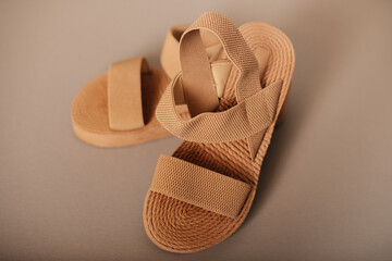 Beige summer sandals on pastel background