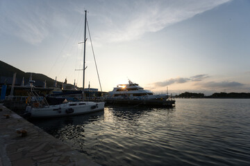 Fototapeta premium 夕焼けの海岸の港に泊まっている船