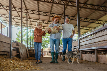 Cute scene from a farm as a farmer carries a lamb in his arms © bernardbodo