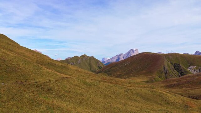Veduta aerea mozzafiato delle Dolomiti con valli verdi, sentieri alpini e imponenti montagne rocciose sotto un cielo limpido. Un paesaggio naturale spettacolare che rappresenta la bellezza delle Alpi