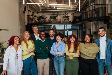 Start-up team smiling with folded arms in modern office