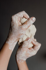 Close up of woman hands molding white clay, creative process