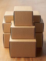 Stack of Plain Cardboard Boxes on a Wooden Surface Waiting for Packing and Shipping
