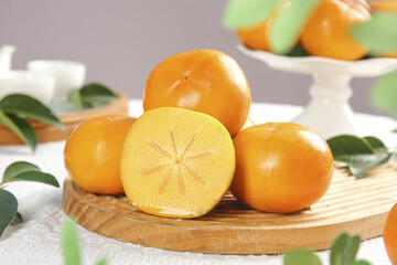 Fresh Ripe Persimmons on Wooden Board - Sweet Autumn Fruit with Star Pattern Inside