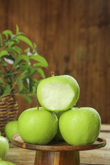 Fresh Green Apples with Water Droplets on Rustic Wooden Stand - Healthy Organic Fruit Ready for Picking