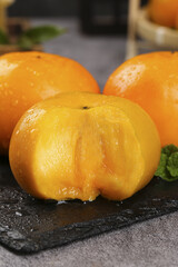 Fresh Ripe Persimmons with Water Droplets on Slate Board - Sweet Orange Fruit