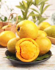 Fresh Golden Lucuma Fruits with Creamy Orange Flesh on Rustic Wooden Table - Tropical Superfood from Peru