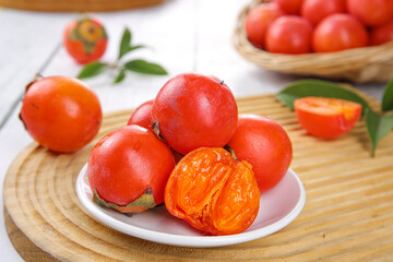 Fresh Orange Persimmons on White Plate with Wooden Board and Basket - Healthy Fruit Still Life