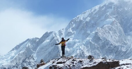 Drone shot of a tourist standing tall amidst Lhotse peak on the Everest Base Camp trek in Khumbu, Nepal. A 360° aerial reveals snow-capped Himalayas, breathtaking scenery, and high-altitude adventure - Powered by Adobe