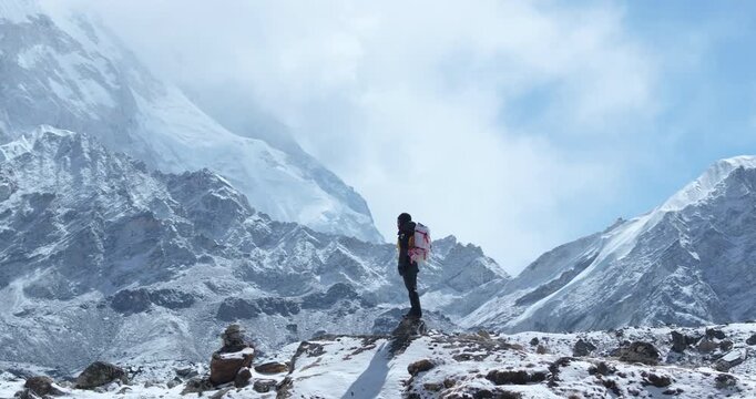 Drone shot of a tourist standing in awe beneath Lhotse peak on Everest Base Camp trek, Khumbu, Nepal. Morning light reveals snow-capped Himalayan heritage, breathtaking scenery, and adventure travel