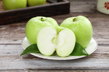 Fresh Green Shaanxi Apples on Plate - Tree-Ripened Fruit with Water Droplets on Rustic Wood Table