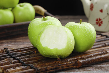 Fresh Green Shaanxi Apples with Water Drops on Bamboo Mat - Organic Tree-Ripened Fruit