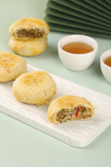 Traditional Chinese Mooncakes with Tea - Delicious Asian Pastries with Mixed Filling on White Plate