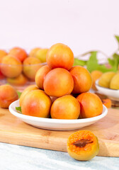 Fresh Xinjiang Apricots in Shallow Bowls - Organic Stone Fruit Display on Wooden Board