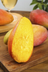 Fresh Sliced Mango with Golden Yellow Flesh on Wooden Cutting Board - Tree Ripened Tropical Fruit with Rainbow Colors