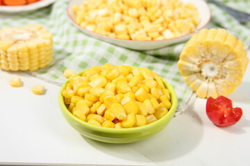 Fresh Golden Corn Kernels in Bowls with Corn Cobs Display on White Wooden Table
