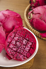 Fresh Red Dragon Fruit from Vietnam on Wooden Table with Traditional Wicker Basket Display