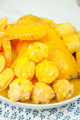 Golden Chicken Pork Meatball Soup with Onion Rings in White Bowl Asian Comfort Food