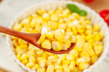 Fresh Golden Sweet Corn Kernels on Wooden Spoon from Bowl - Healthy Natural Vegetable Ingredient