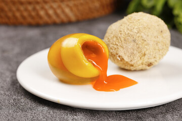 Soft-boiled chicken egg with runny yolk and bread roll on white plate