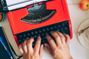 Typing on red typewriter with tea