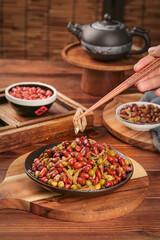 Traditional Chinese Stir-Fried Peanuts Baby Fish and Vinegared Peas Dish with Chopsticks on Wooden Table