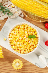 Fresh Golden Corn Kernels in Bowl with Corn Cobs on Wooden Table - Healthy Natural Food Ingredients