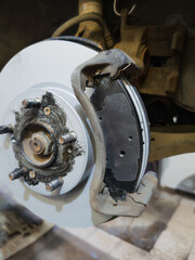 Car brake disc and pad closeup after replacement in workshop auto repair service