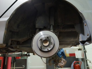 Car brake disc and pad closeup after replacement in auto repair garage