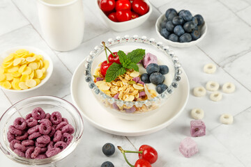 Healthy breakfast yogurt bowl with oats, berries and fresh fruit on marble background