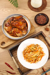 Spicy Asian Chicken and Hand-Shredded Vegetable Dishes on Wooden Table with Traditional Serving Plates