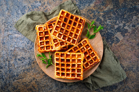 Fresh baked homemade Brussels waffles served as top view on a rustic design plate