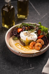 Bowl with hummus, poached egg, shrimp and fresh vegetable salad