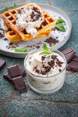 Fresh baked homemade Belgian Brussels waffles with mascarpone cream fresh and dark chocolate topping served as close-up on a design plate