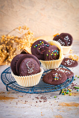 Artisan homemade fine dark chocolate thaler decorated with colorful sugar pearls in muffin moulds
