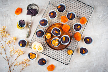 Artisan homemade pralines with dried apricots, fruits and nuts,  coated with fine bitter dark chocolate