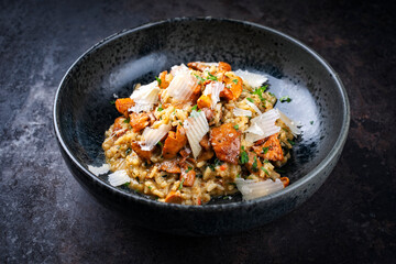Traditional Italian risotto con finferli with fresh chanterelles and rparmesan served as close-up in a Nordic design bowl