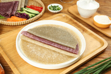 Savory Crepe with Sausage and Cheese Served with Fresh Vegetables and Cooking Ingredients