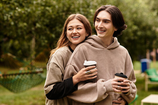 Young couple enjoying a lovely moment outdoors with coffee in a serene garden setting