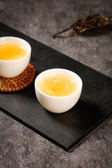 Freshly Brewed Biluochun Green Tea in White Cups on Slate Board with Traditional Coaster